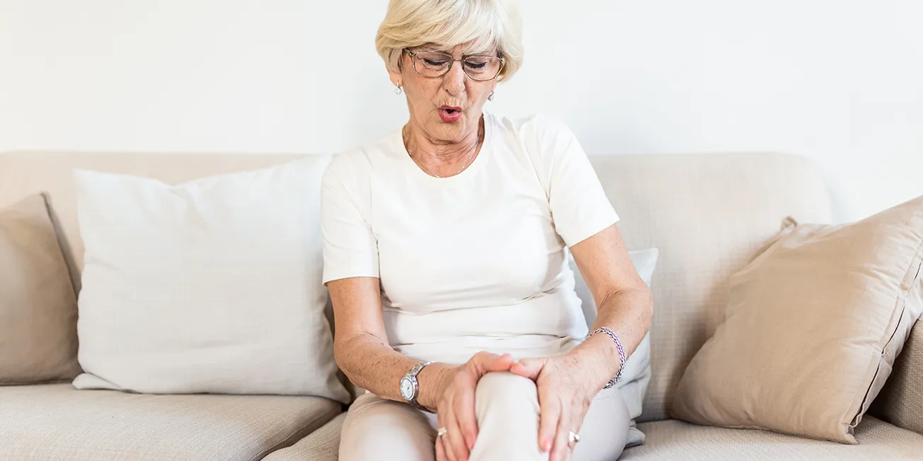 Kvinne med smerter i kne.