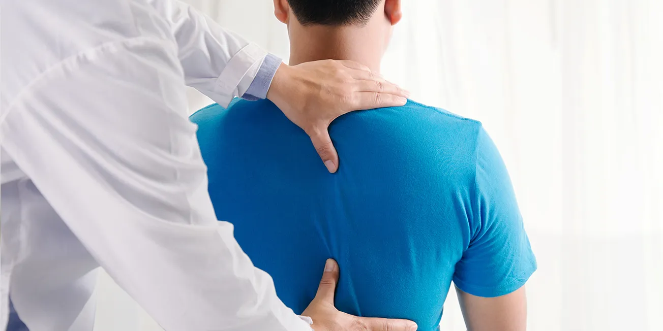 Mann får behandling av ryggen hos kiropraktor.