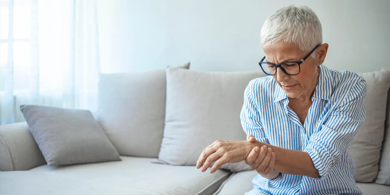 Dame med smerte i hånd.