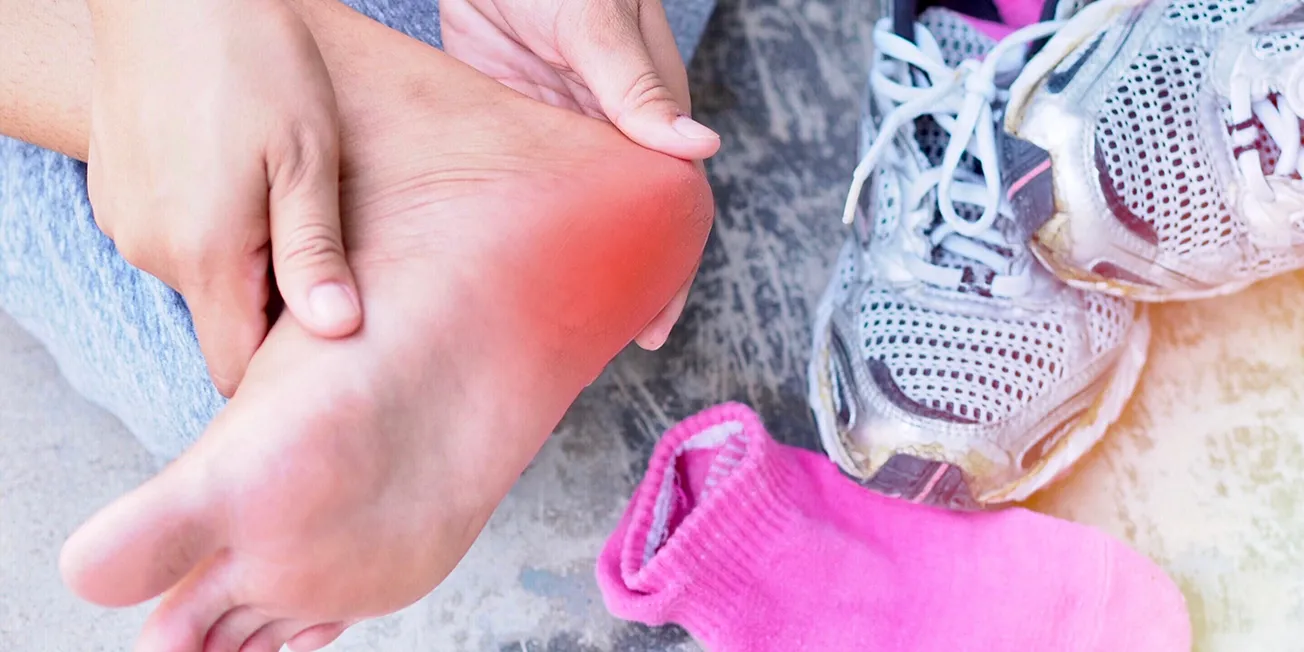 Dame med smerter under fot.