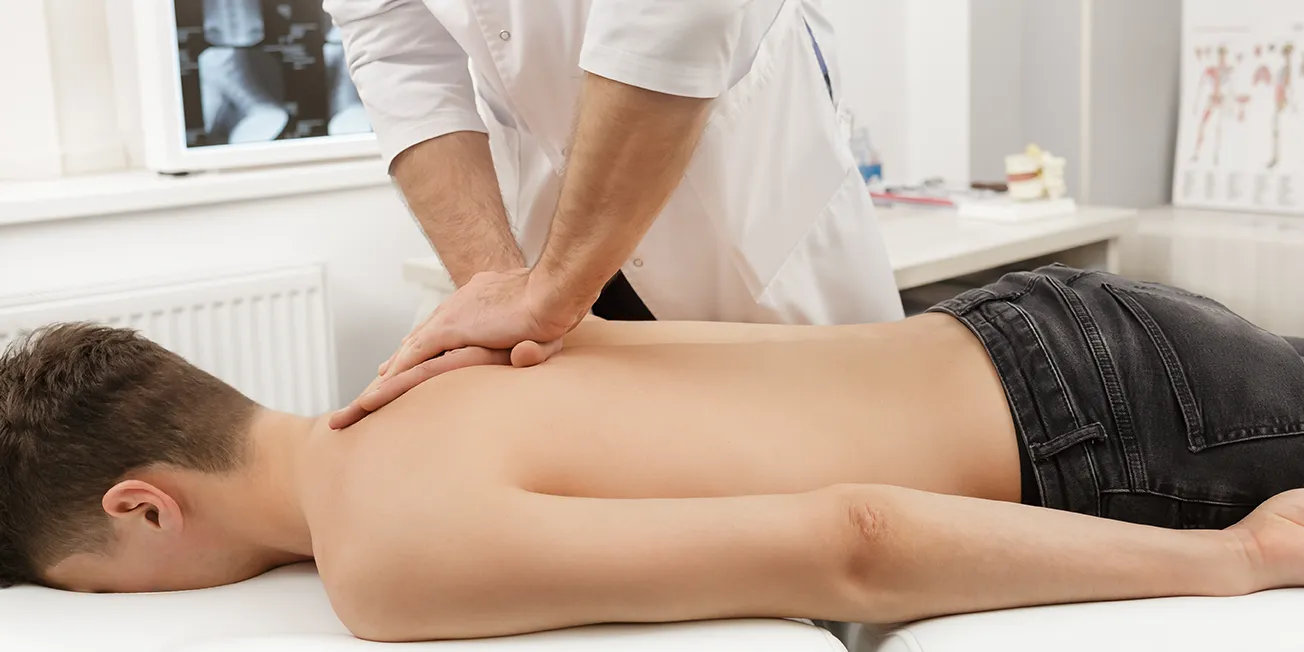 Ung mann behandles hos kiropraktor.